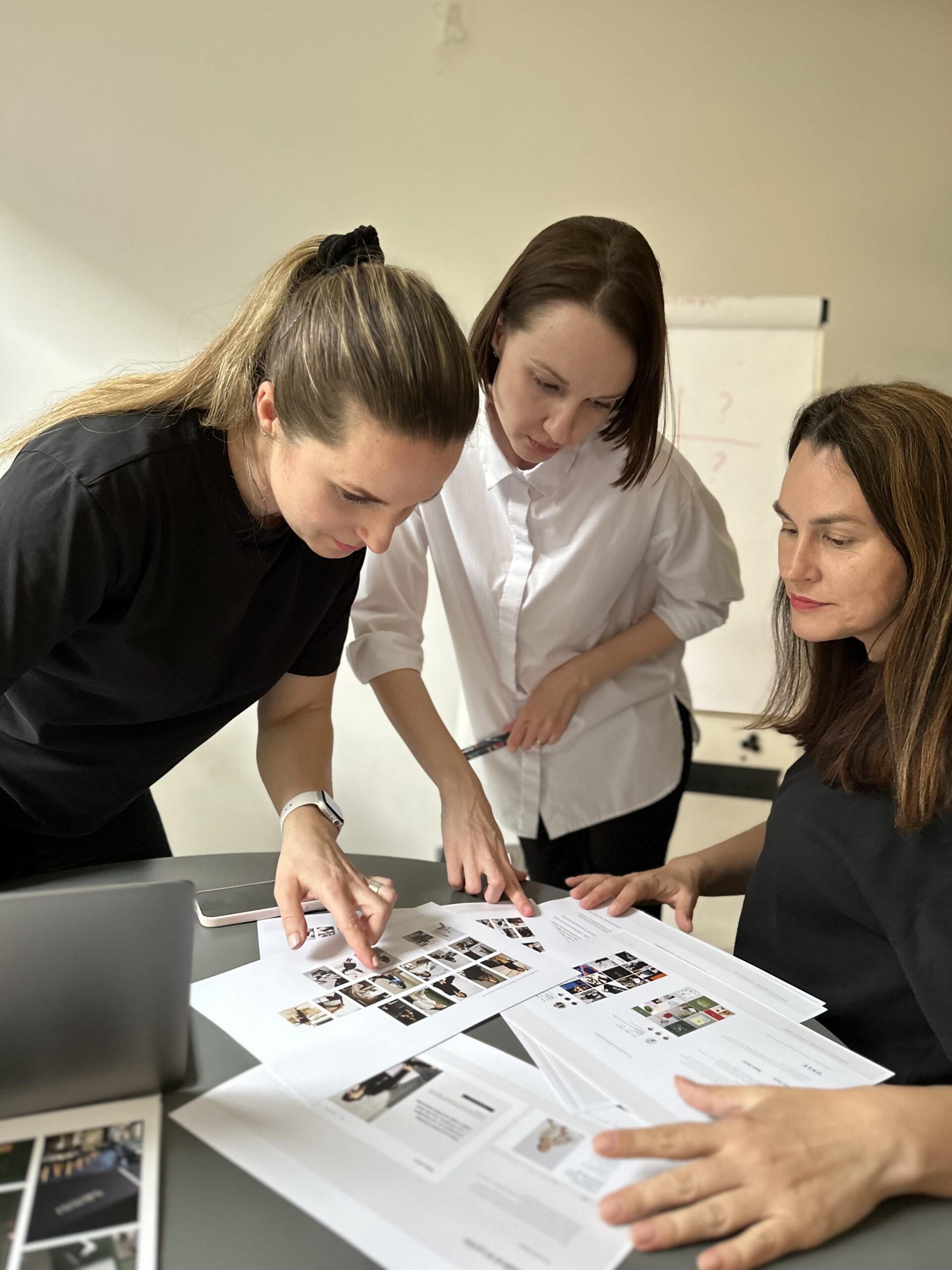 Team som arbeider med visuell identitet og designmateriale ved et bord.